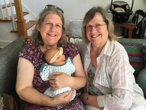 Jeane holding the new baby, with Chris sitting next to her
